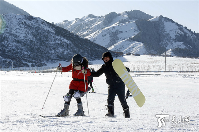 在白云國(guó)際滑雪場(chǎng)內(nèi),一位初學(xué)者在同伴的攙扶下學(xué)習(xí)滑雪。